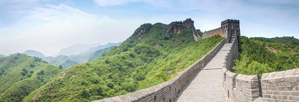 Bildet skildrer Den kinesiske mur som bukter seg gjennom et frodig, grønnklædt landskap.