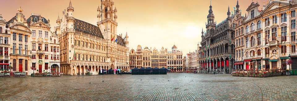 Bilde av den storslåtte Grand Place, eller Grote Markt, i Brussel med historiske bygninger i solnedgang.