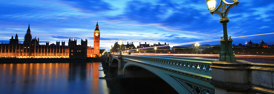 Westminster Bridge og Big Ben ved blåtimen med lysstriper og opplyst parlament.