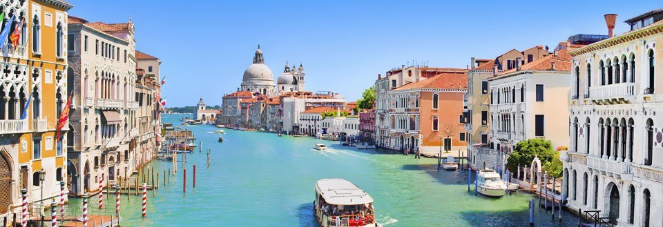 Den livlige Grand Canal i Venezia, omgitt av fargerike bygninger og båter.